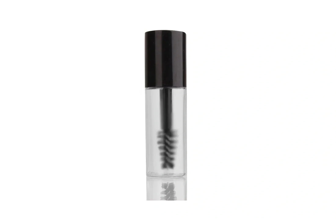 Indigo Private Label clear brow gel in a transparent tube with a black cap and spoolie brush.
