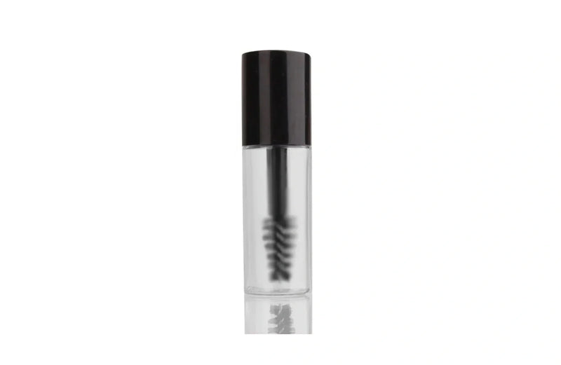 Indigo Private Label clear brow gel in a transparent tube with a black cap and spoolie brush.
