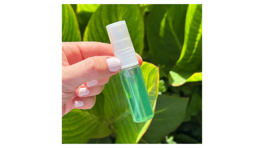 Indigo Private Label hair growth serum bottle held in hand against a leafy background.
