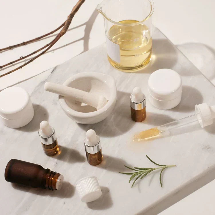 Skincare formulation tools and amber dropper bottles from Indigo Private Label on a marble slab.
