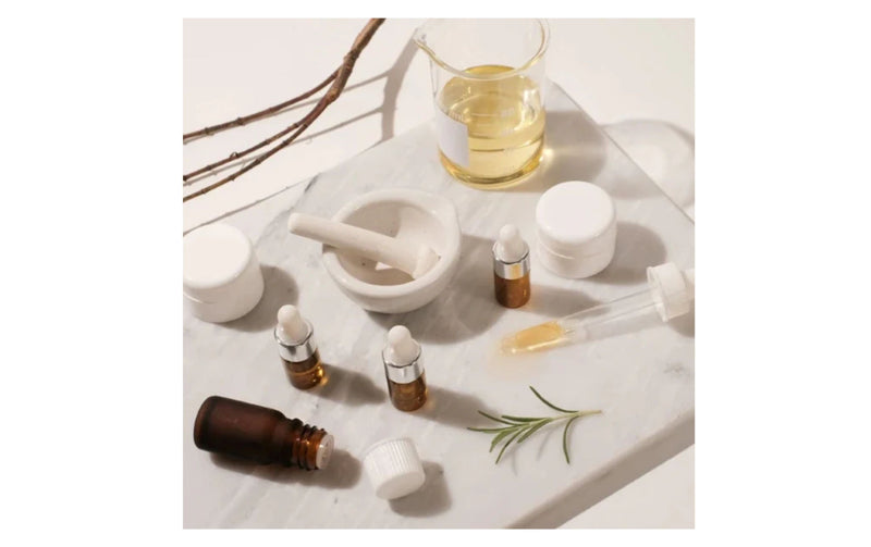 Indigo Private Label skincare formulation workspace with serum droppers, mortar, and lab glassware.
