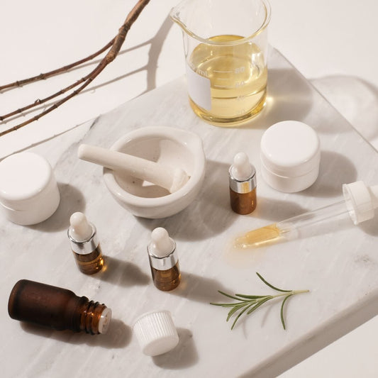 Indigo Private Label skincare formulation tools, botanical oils, jars, droppers, and a mortar and pestle.