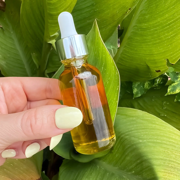Bakuchiol Serum in an amber glass dropper bottle with a green botanical background.